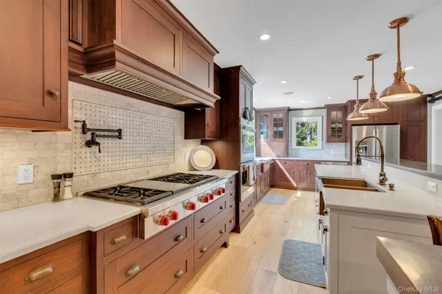 a kitchen with stainless steel appliances granite countertop a sink stove and cabinets