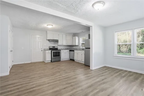 a view of kitchen with wooden floor and electronic appliances