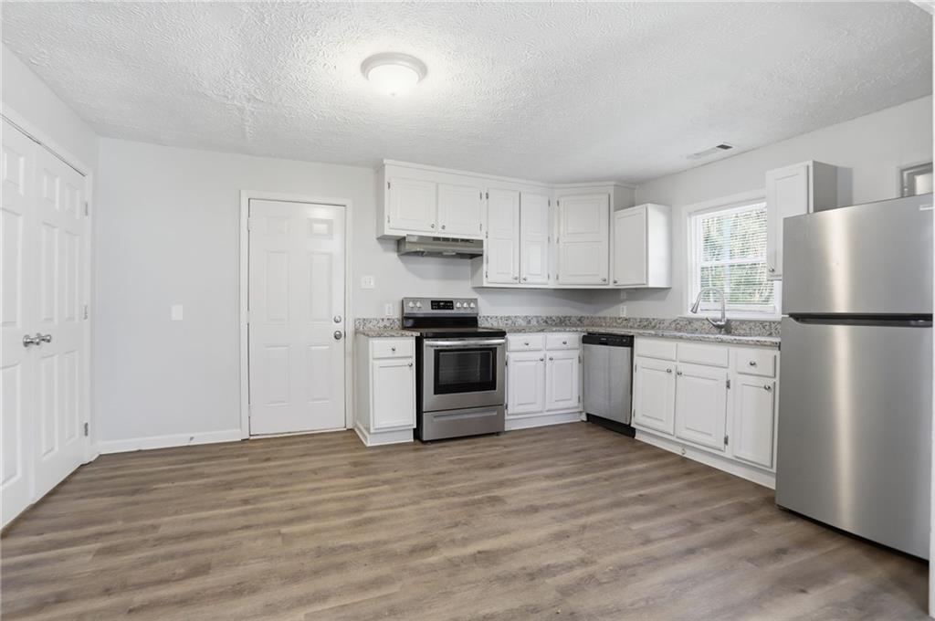 714 Reed Street Monroe, GA 30655 - Photo 12 of 31 a kitchen with granite countertop white cabinets and stainless steel appliances