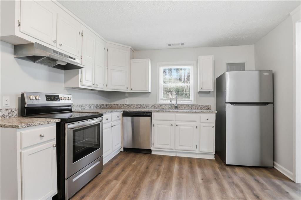 714 Reed Street Monroe, GA 30655 - Photo 13 of 31 a kitchen with a white cabinets and white appliances