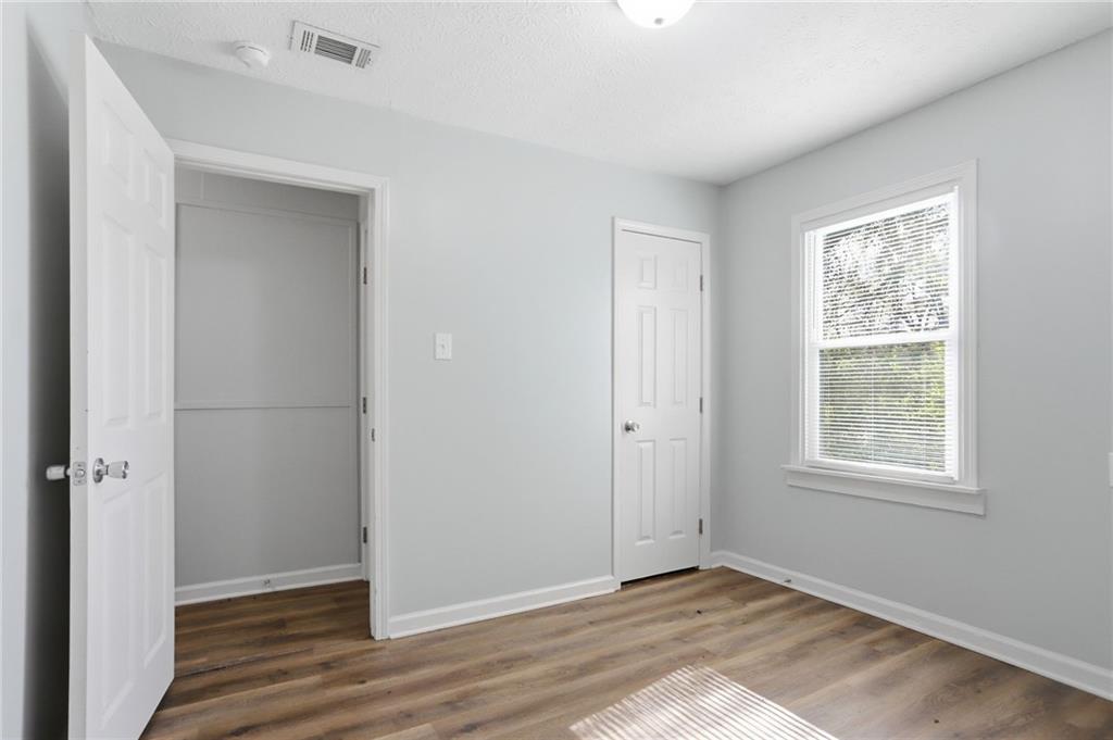714 Reed Street Monroe, GA 30655 - Photo 16 of 31 a view of an empty room with wooden floor and a window