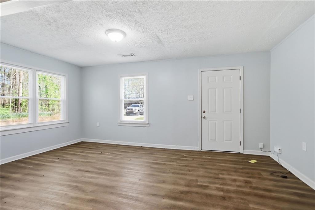 714 Reed Street Monroe, GA 30655 - Photo 9 of 31 an empty room with wooden floor and windows