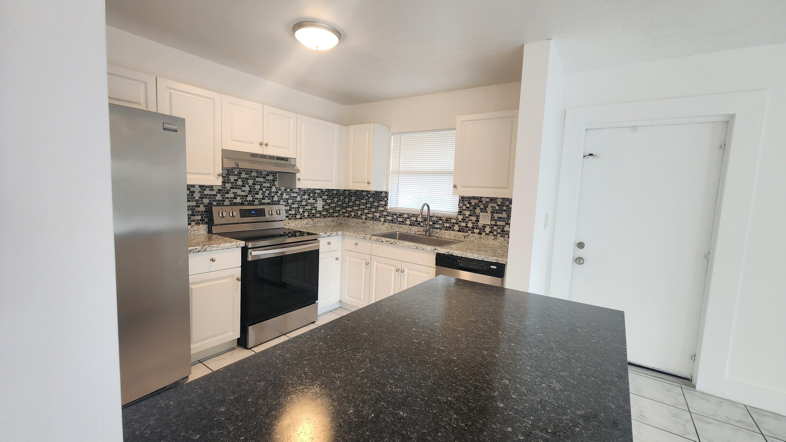 517 Dotterel Road, Unit 31C Delray Beach, FL 33444 - Photo 2 of 31 a kitchen with a stove a sink and a refrigerator