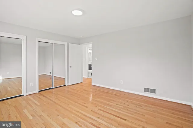 an empty room with a window and wooden floor