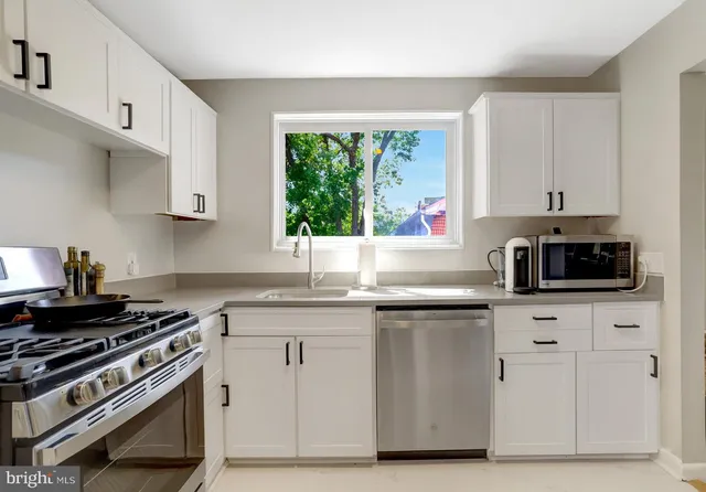 a bathroom with a granite countertop sink a toilet a mirror and bathtub