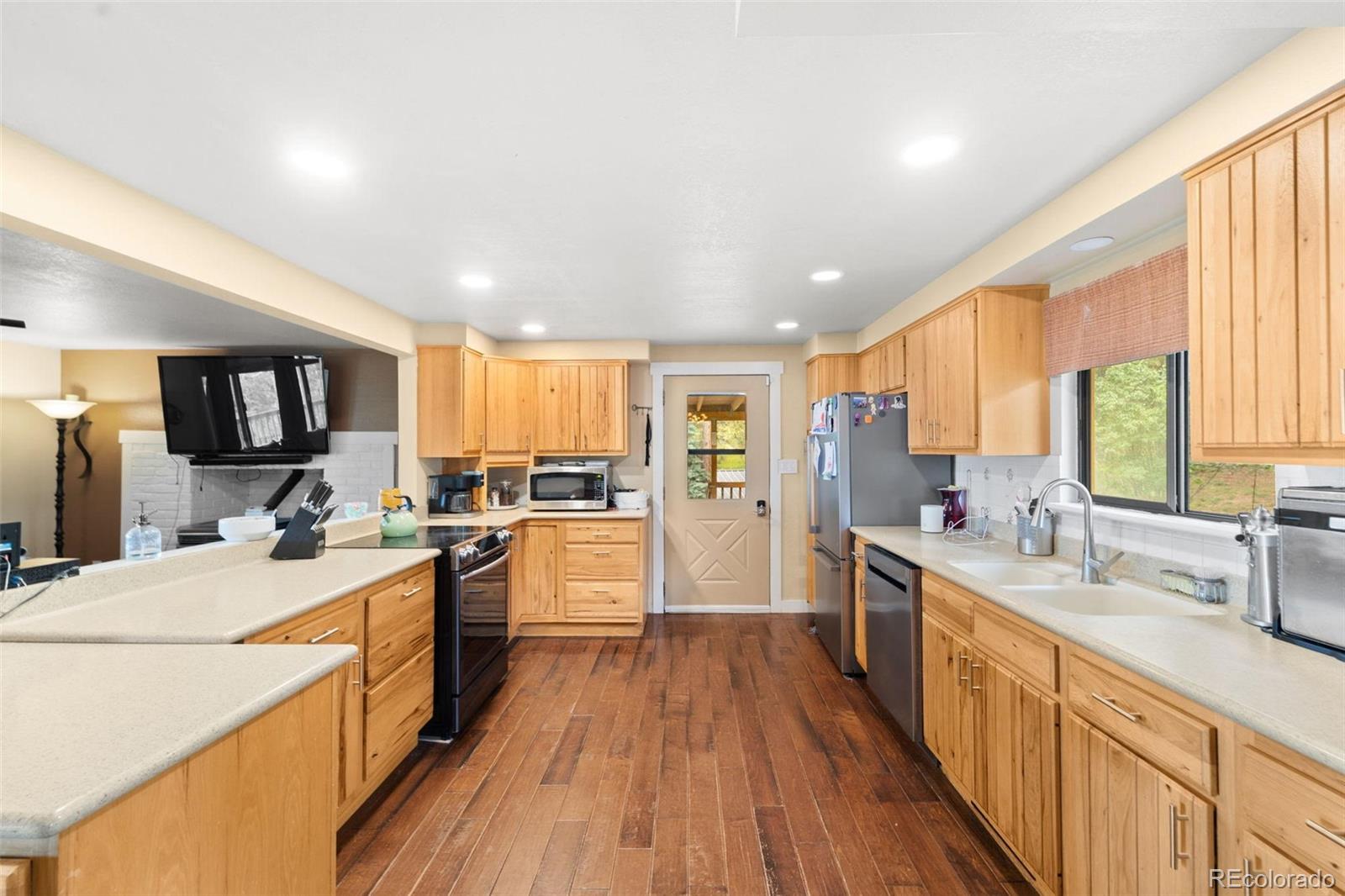 10829 Bartlett Trail Rye, CO 81069 - Photo 9 of 40 a kitchen with a sink a counter top space stainless steel appliances cabinets and a window
