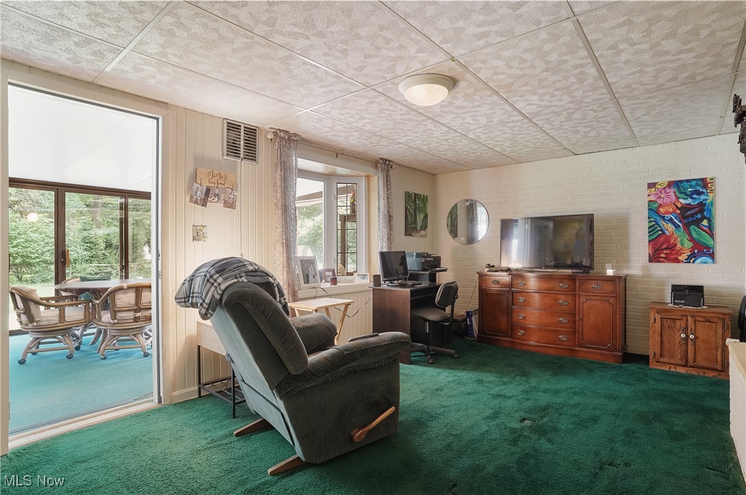 2829 Lee Road Silver Lake, OH 44224 - Photo 19 of 30 Living room with carpet floors, brick wall, and a paneled ceiling