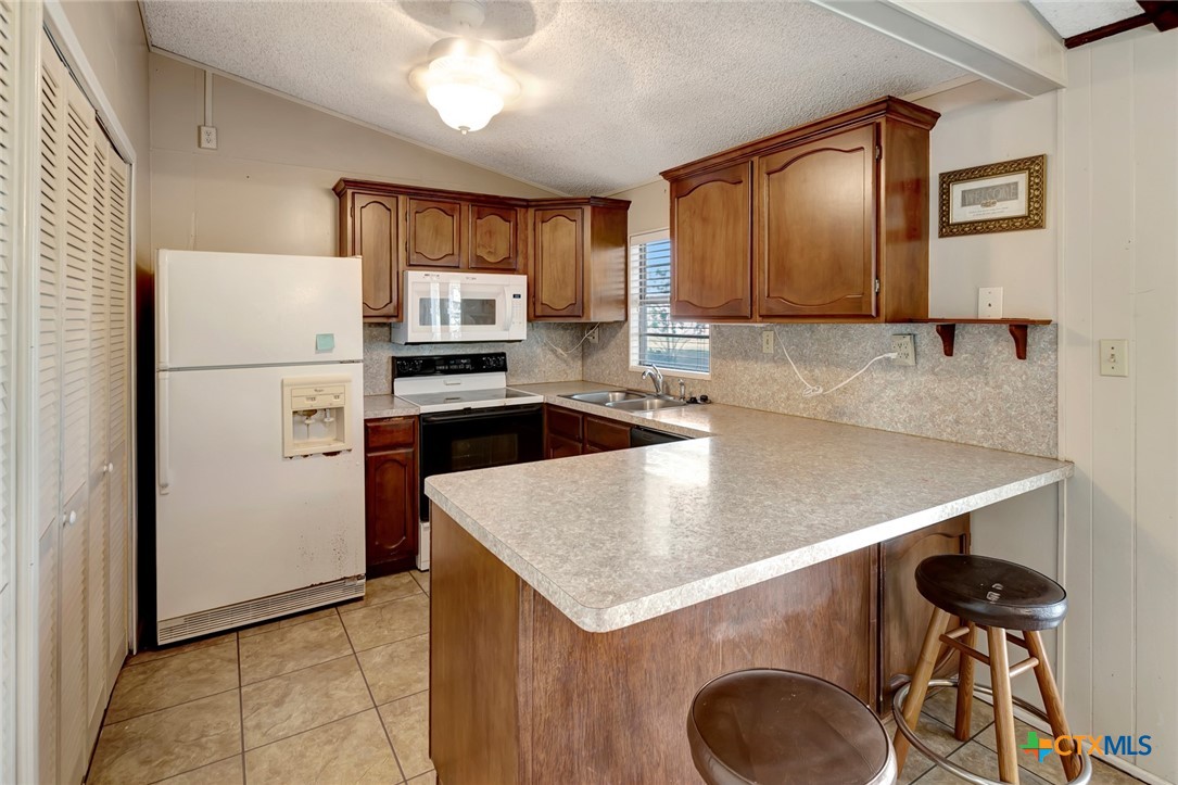 293 County Road 406 Edna, TX 77957 - Photo 18 of 48 a kitchen with a refrigerator a sink and a stove top oven