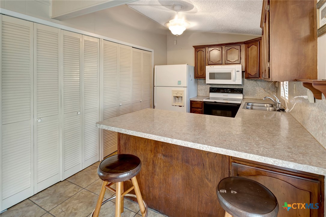 293 County Road 406 Edna, TX 77957 - Photo 19 of 48 a kitchen with stainless steel appliances a sink a stove a refrigerator and cabinets