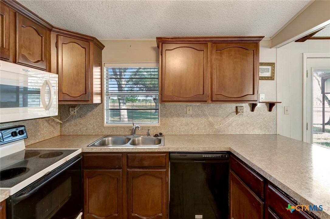 293 County Road 406 Edna, TX 77957 - Photo 20 of 48 a kitchen with stainless steel appliances granite countertop a sink stove and cabinets