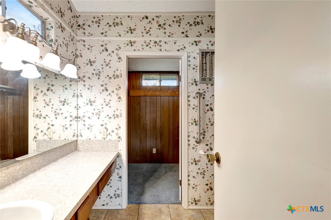 293 County Road 406 Edna, TX 77957 - Photo 25 of 48 a bathroom with a granite countertop sink a mirror and shower