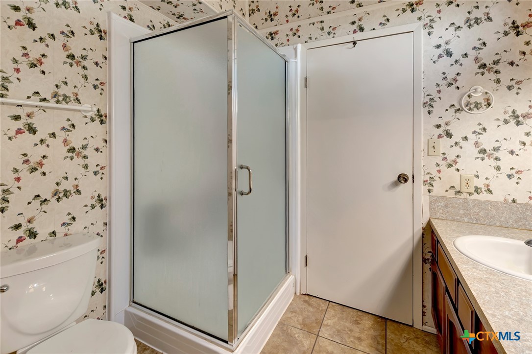 293 County Road 406 Edna, TX 77957 - Photo 27 of 48 a bathroom with a granite countertop sink toilet and shower