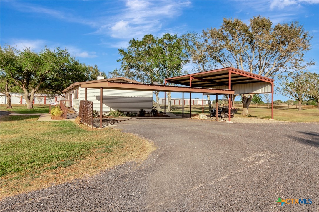 293 County Road 406 Edna, TX 77957 - Photo 9 of 48 a patio area with a table and chairs under an umbrella