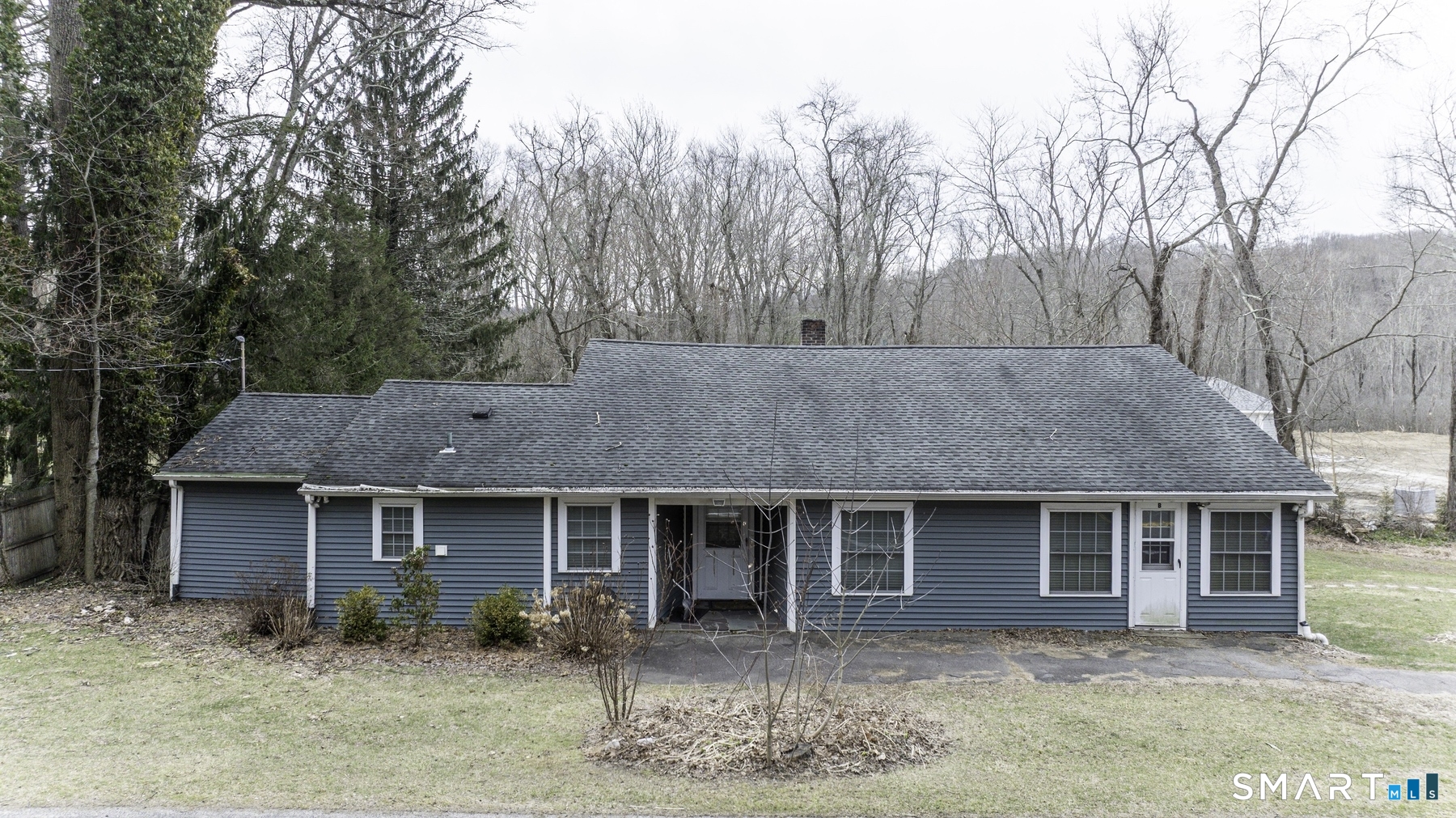 a front view of a house with garden and trees