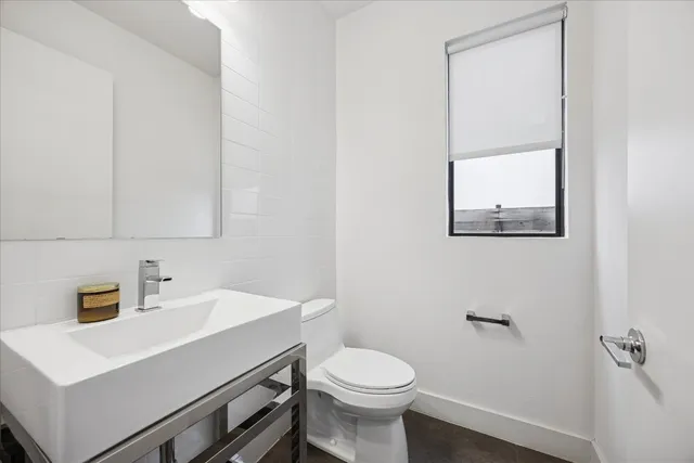 a bathroom with a sink a toilet and mirror