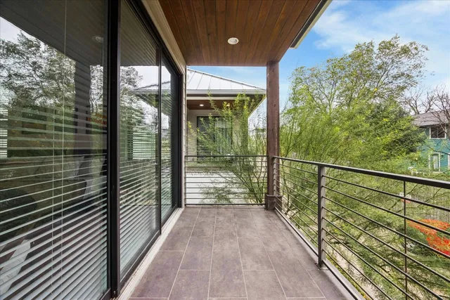 a view of a balcony with floor to ceiling windows with wooden floor