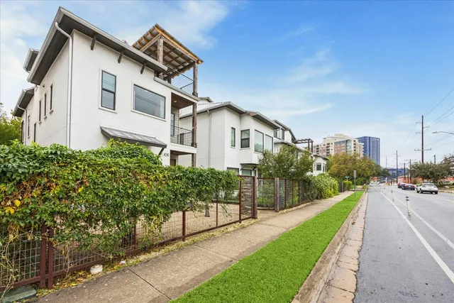 a front view of a house with a yard and potted plants