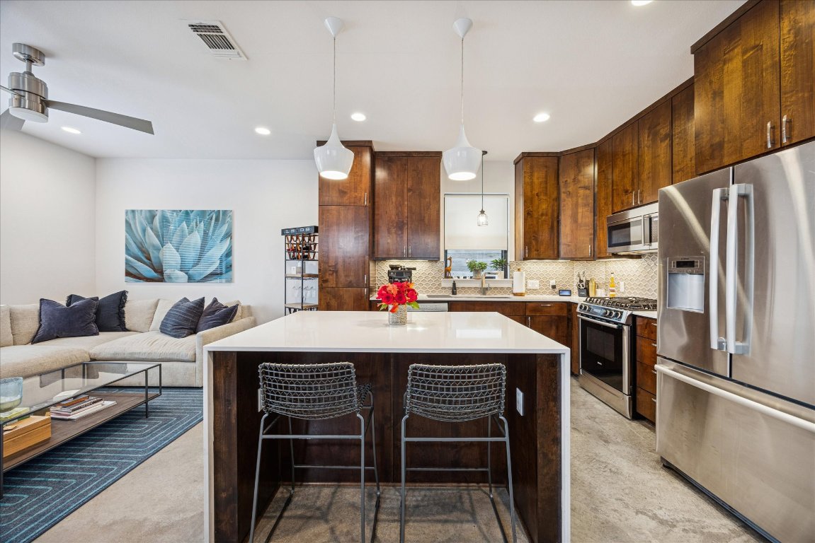 1011 East 12th Street Austin, TX 78702 - Photo 4 of 30 Kitchen featuring stainless steel appliances, a breakfast bar and kitchen Island