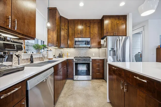 a kitchen with stainless steel appliances granite countertop a sink stove and refrigerator