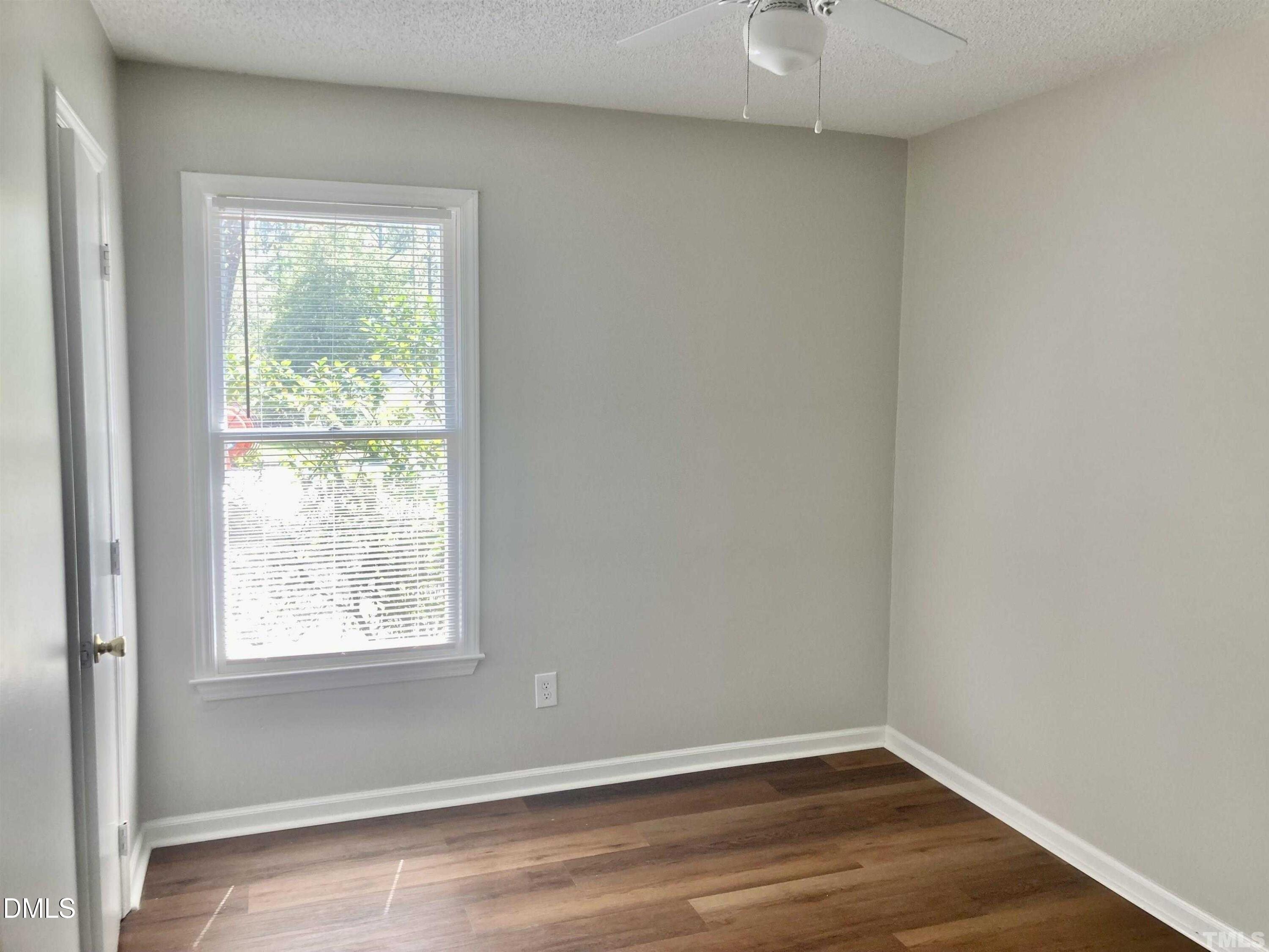 104 Castill Place Garner, NC 27529 - Photo 7 of 11 an empty room with a window and a ceiling fan