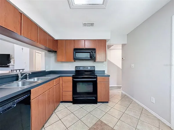 a kitchen with granite countertop a sink and steel appliances