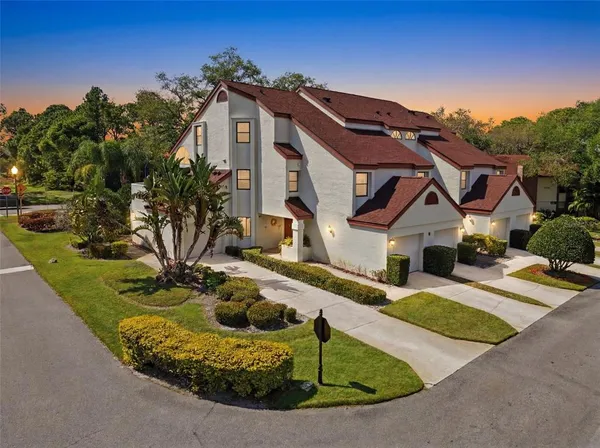 a view of a house with a small yard and potted plants