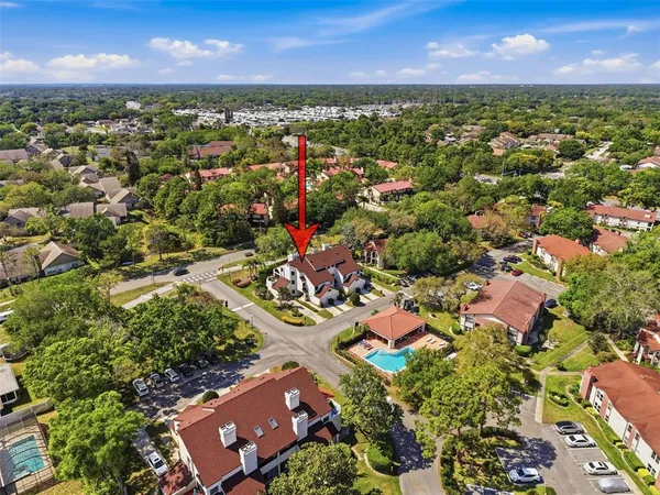 an aerial view of residential houses with outdoor space and trees