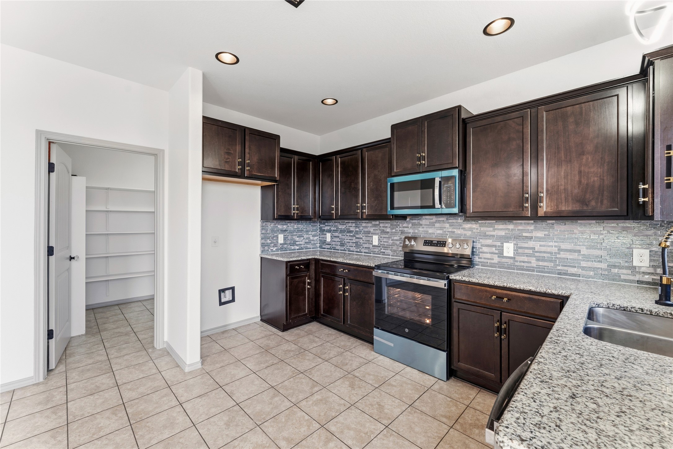 100 Serpentine Lane Jarrell, TX 76537 - Photo 12 of 40 a kitchen with stainless steel appliances granite countertop a refrigerator and a stove top oven
