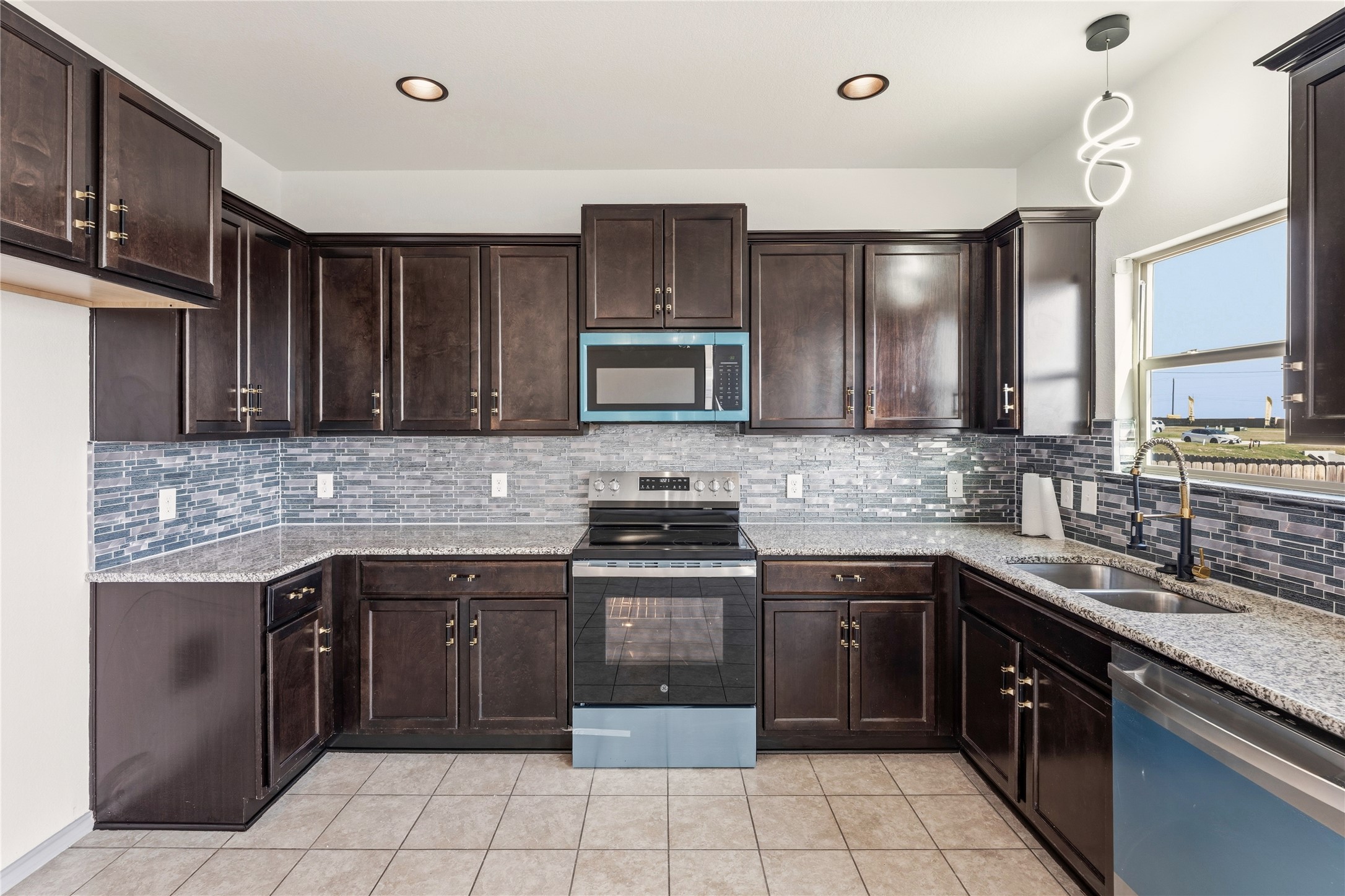 100 Serpentine Lane Jarrell, TX 76537 - Photo 13 of 40 a kitchen with a sink stove top oven and cabinets