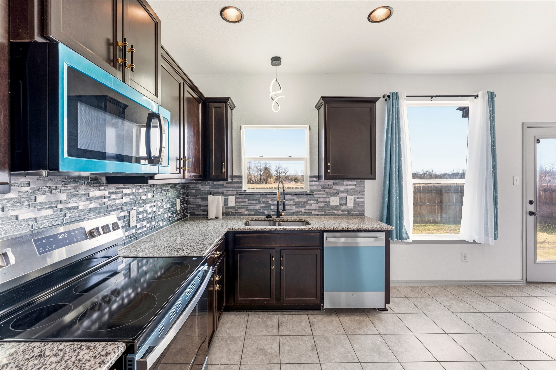 100 Serpentine Lane Jarrell, TX 76537 - Photo 14 of 40 a kitchen with a sink stove and cabinets