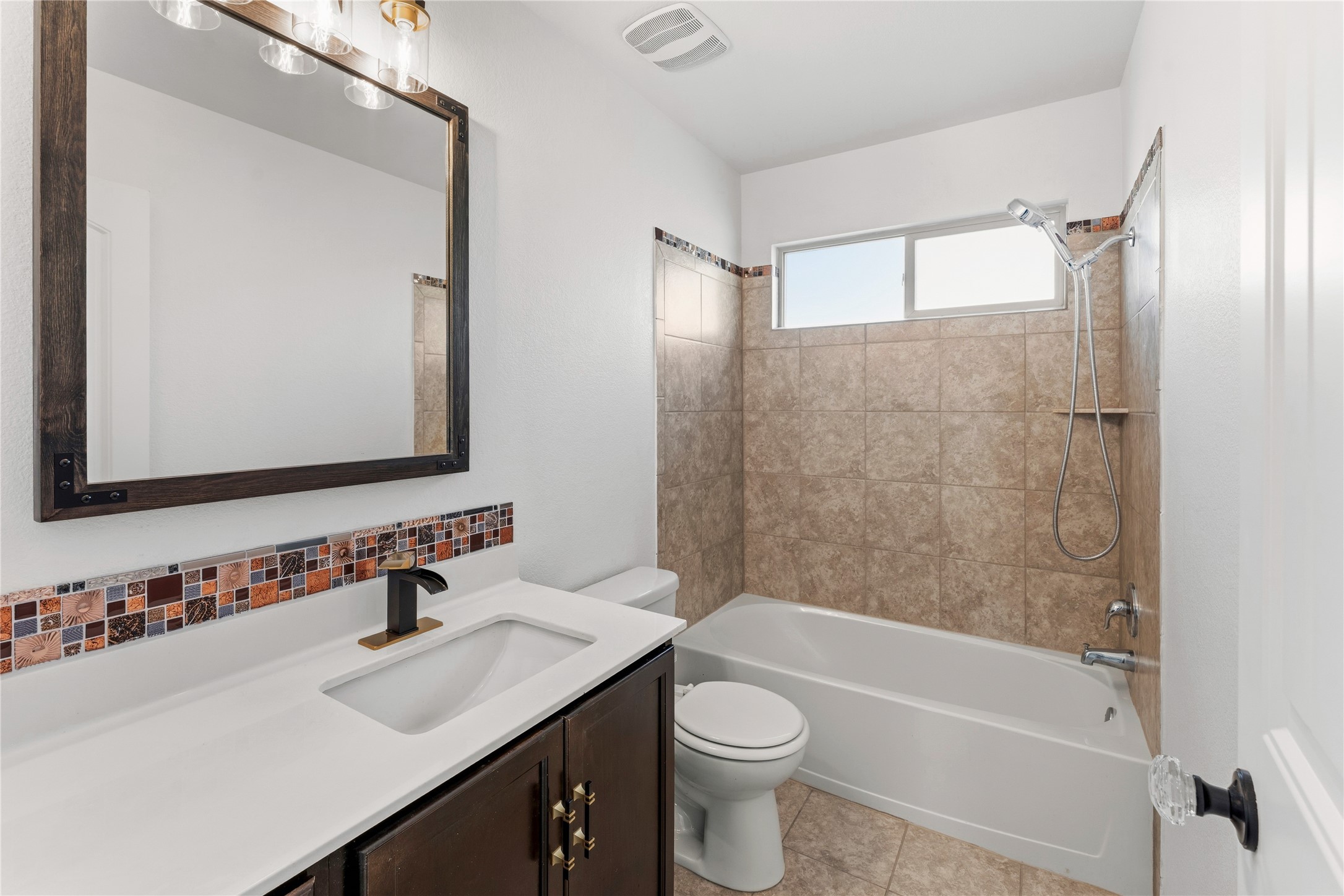 100 Serpentine Lane Jarrell, TX 76537 - Photo 33 of 40 a bathroom with a sink a toilet a mirror a bathtub and shower