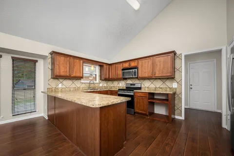 a kitchen with stainless steel appliances granite countertop a stove sink and cabinets