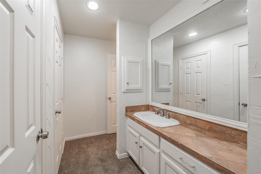 9999 Boat Club Road, Unit 311 Fort Worth, TX 76179 - Photo 23 of 25 a bathroom with a granite countertop sink and a mirror