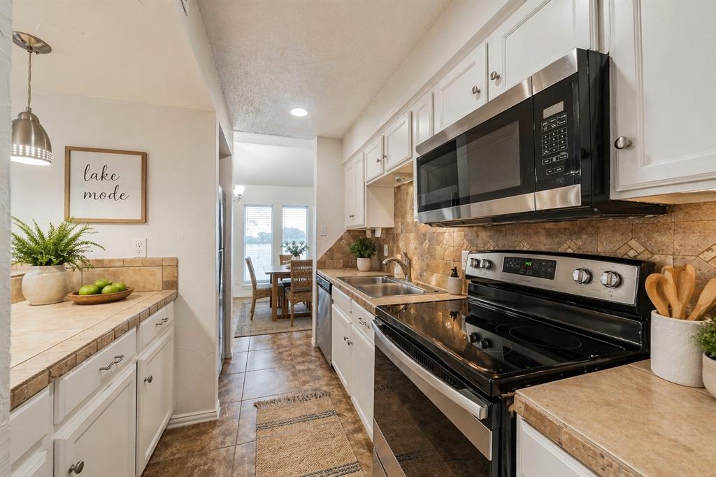 9999 Boat Club Road, Unit 311 Fort Worth, TX 76179 - Photo 6 of 25 a kitchen with a stove and a microwave
