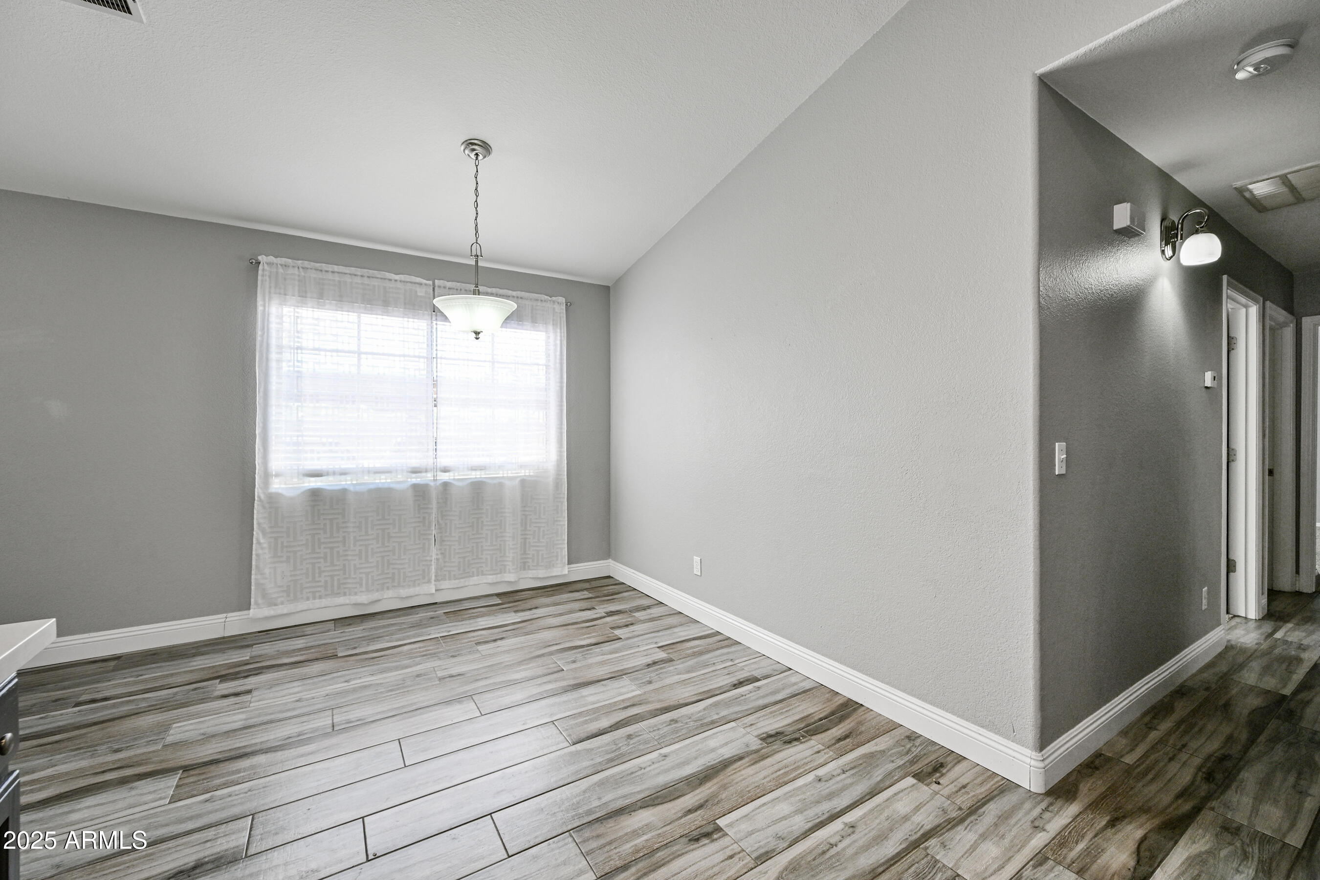 726 South Nebraska Street, Unit 91 Chandler, AZ 85225 - Photo 12 of 20 a view of an empty room with wooden floor and a window