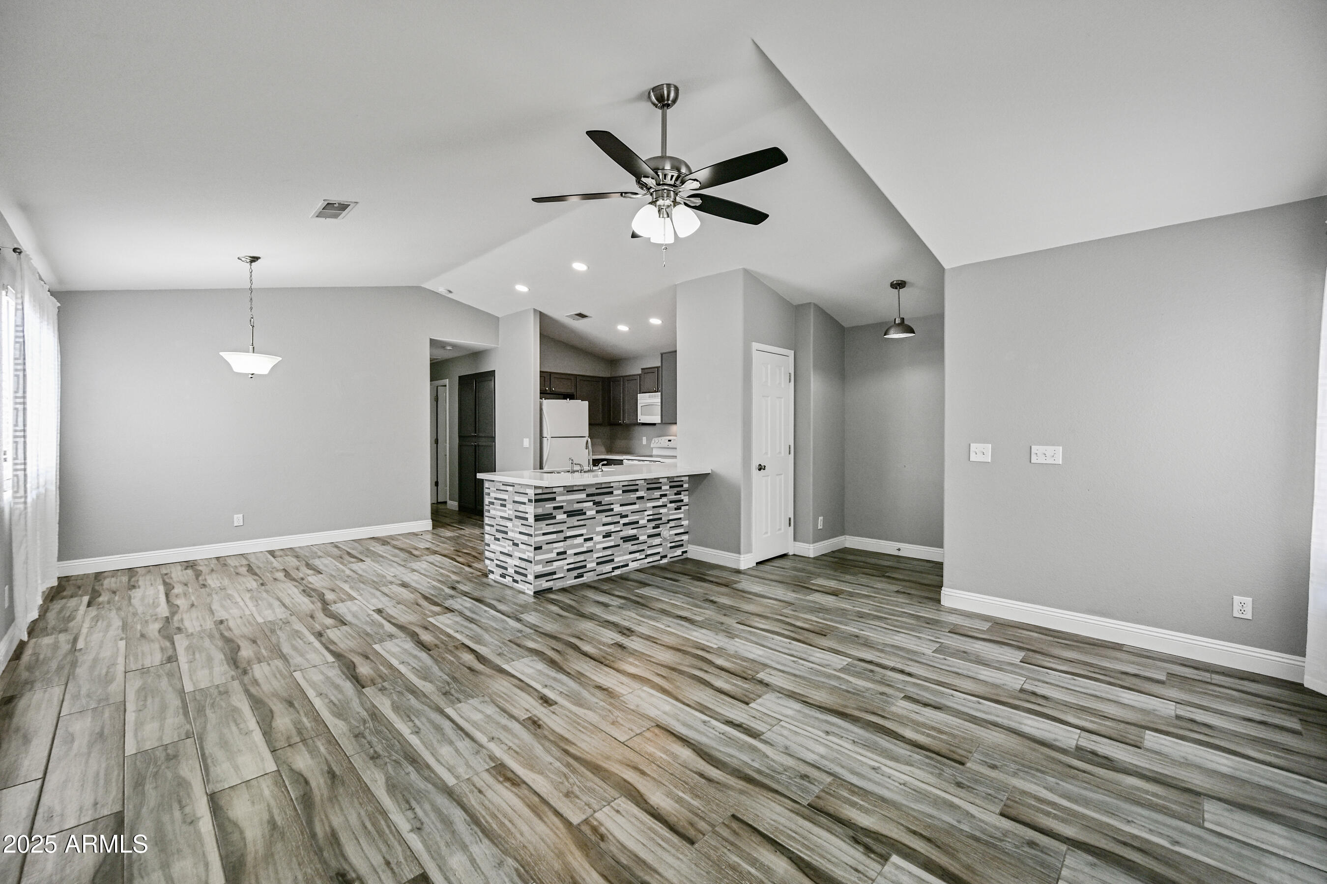 726 South Nebraska Street, Unit 91 Chandler, AZ 85225 - Photo 6 of 20 a view of an empty room with a window and wooden floor