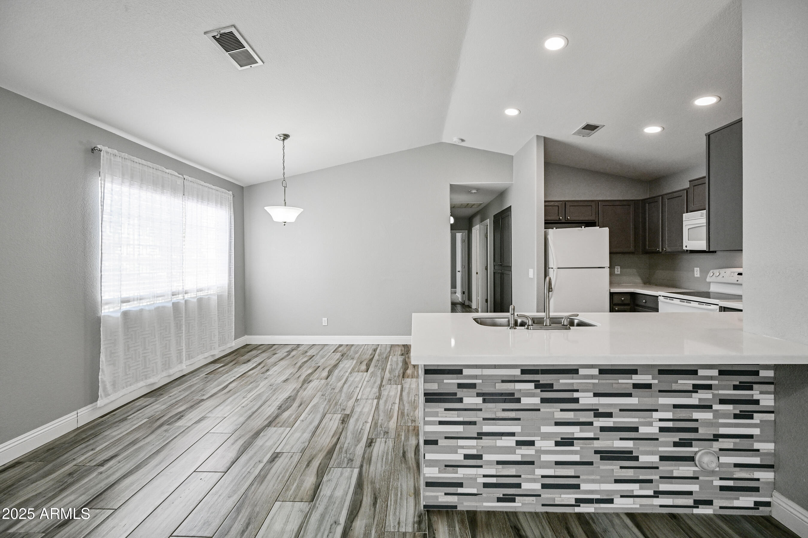 726 South Nebraska Street, Unit 91 Chandler, AZ 85225 - Photo 7 of 20 a kitchen with kitchen island a counter top space a sink and stainless steel appliances