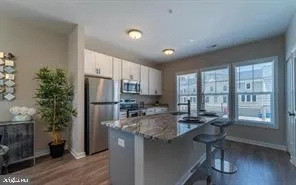 a kitchen with stainless steel appliances granite countertop sink refrigerator and cabinets