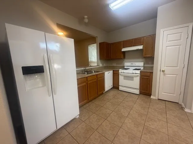 a kitchen with stainless steel appliances granite countertop a stove a sink and a refrigerator