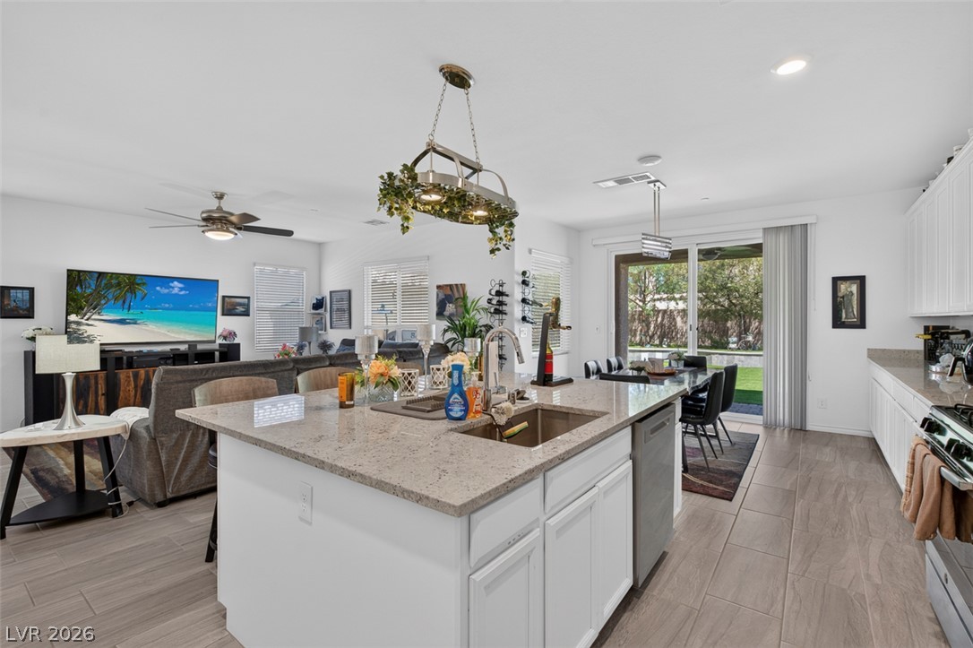 1824 Redland Ridge Street Henderson, NV 89002 - Photo 11 of 69 An open-concept living space integrates a well-appointed kitchen island, a dining area, and a comfortable living room.