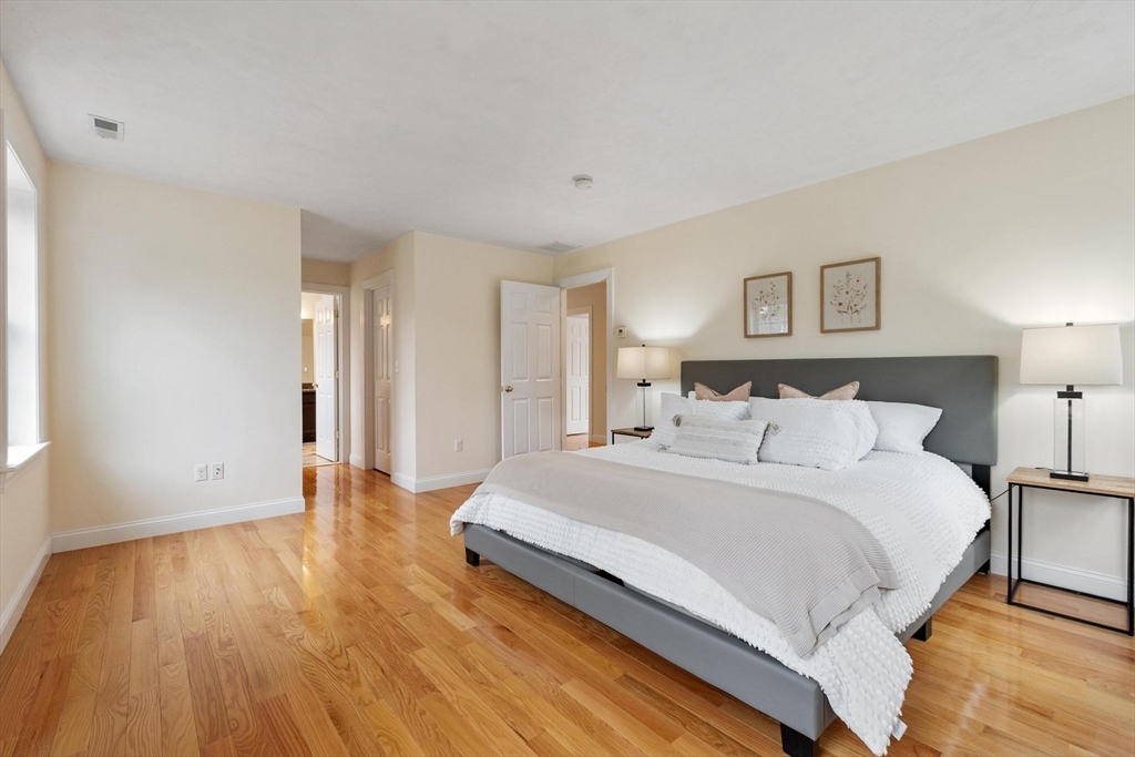 4 Henley Road Acton, MA 01720 - Photo 21 of 32 a spacious bedroom with a bed and a wooden floor