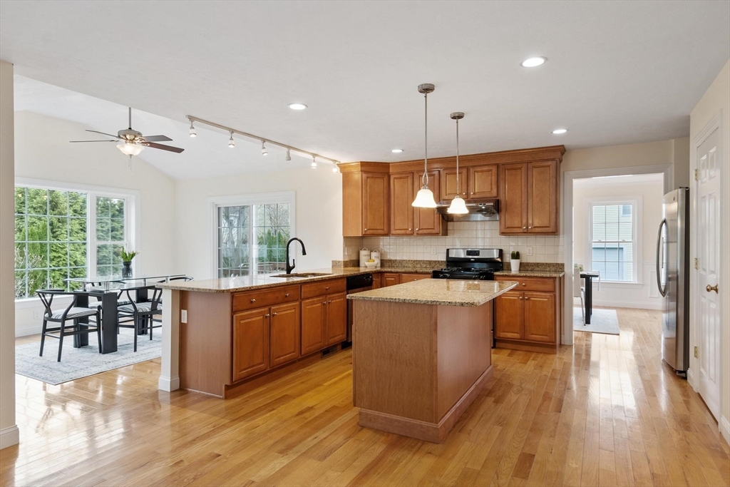 4 Henley Road Acton, MA 01720 - Photo 5 of 32 a kitchen with stainless steel appliances granite countertop wooden floors stove top oven and cabinets