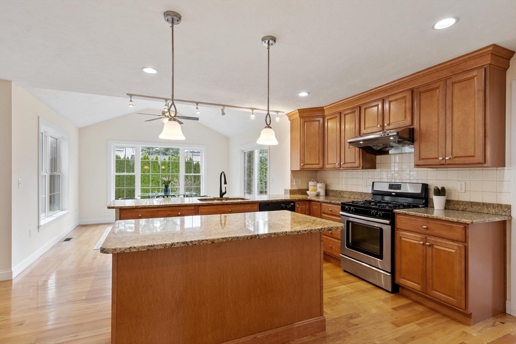 4 Henley Road Acton, MA 01720 - Photo 6 of 32 a large kitchen with kitchen island granite countertop wooden cabinets a stove a sink and dishwasher