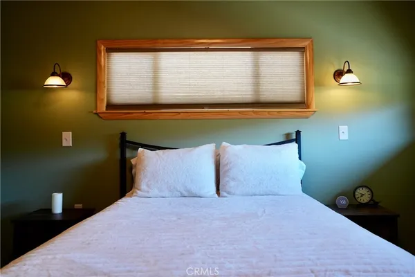 a bedroom with two beds and painting on the wall