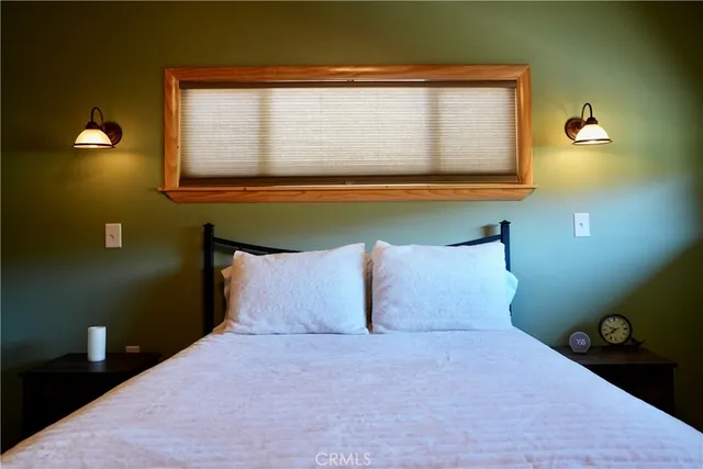 a bedroom with two beds and painting on the wall