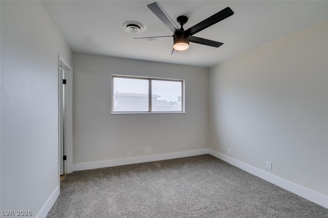 4036 Maple Hill Road Las Vegas, NV 89115 - Photo 33 of 43 A well-lit bedroom features plush carpeting and a modern ceiling fan, offering a comfortable personal retreat.