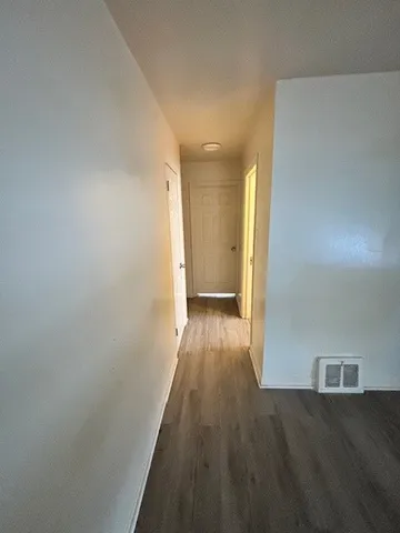 a view of a hallway with wooden floor