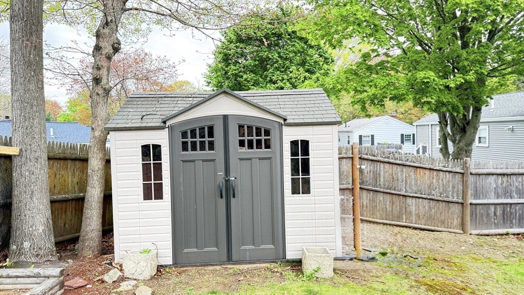 118 Spruce Road Norwood, MA 02062 - Photo 21 of 39 a view of a white house with large windows and a tree