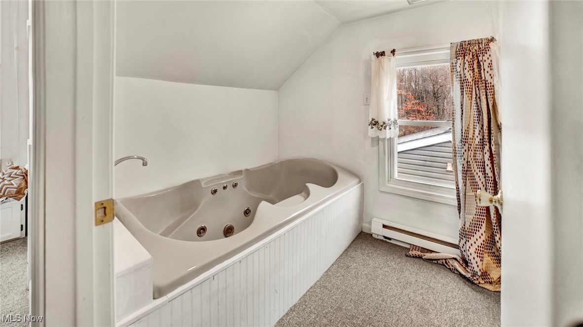 337 Pomerene Road Mansfield, OH 44906 - Photo 16 of 32 Bathroom with a tub to relax in, a baseboard heating unit, and lofted ceiling
