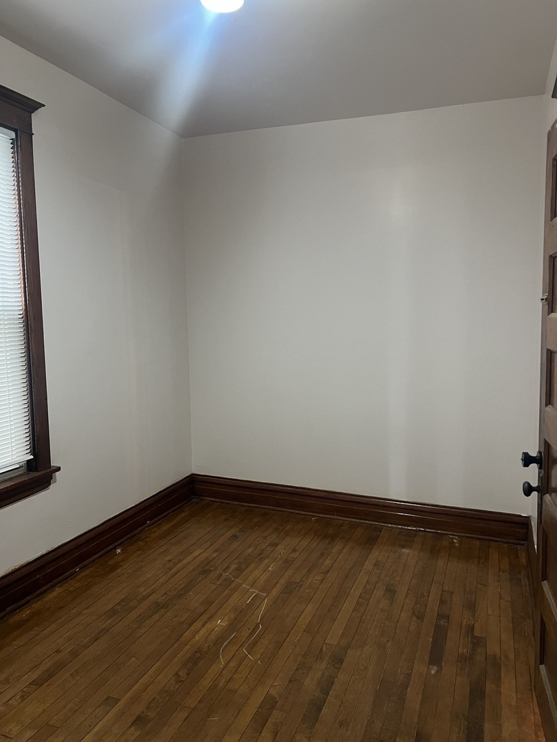 1921 North Pulaski Road, Unit 1 Chicago, IL 60639 - Photo 11 of 16 a view of an empty room with wooden floor and a window